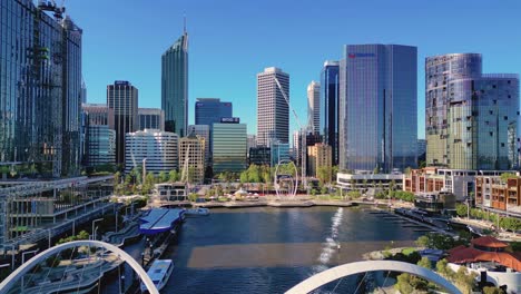 Aerial-drone-top-down-shot-over-walking-bridge--Elizabeth-Quay-surrounded-by-tall-buildings-in-Perth,-Western-Australia,-Australia-on-a-sunny-day