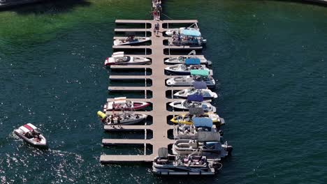 boat-yacht-leaving-the-dock-backing-out-and-people-enjoying-a-good-time-on-Lake-Arrowhead-california-AERIAL-STATIC