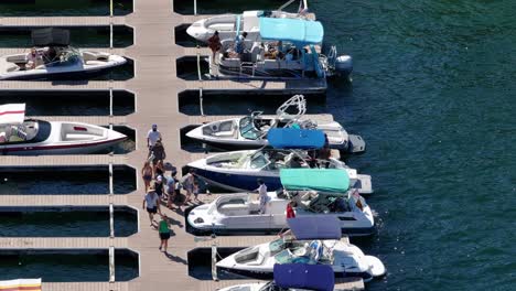 a-family-of-people-boarding-their-yacht-boat-on-Lake-Arrowhead-California-surrounded-by-clear-blue-water-on-a-sunny-day-AERIAL-STATIC