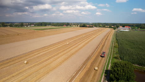 Traktor-Sammelt-Landwirtschaftliches-Heu-An-Einem-Schönen-Tag-Mit-Blauem-Himmel-Und-Wolken