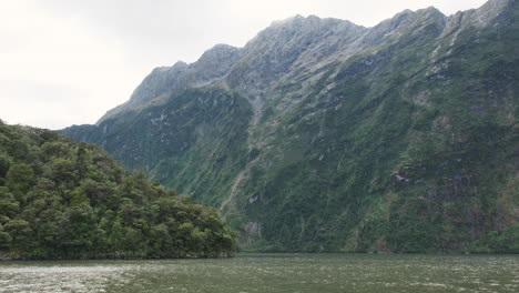 Towering-green-cliffs-of-Milford-Sound-rise-over-tranquil-waters