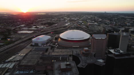 Aerial-view-approaching-the-Caesars-Superdome,-sunny-evening-in-New-Orleans,-USA