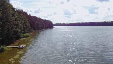 Aerial-Drone-Footage-Over-a-Lake-and-Alongside-a-Forest-in-Borowy-Młyn,-Pomeranian-Voivodeship,-Poland