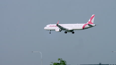 Air-Arabia-Con-Las-Ruedas-Abajo-Volando-Hacia-La-Izquierda-Pasando-Por-Una-Torre-De-Control-De-Tráfico-Aéreo-En-El-Aeropuerto-De-Suvarnabhumi-En-Bangkok.