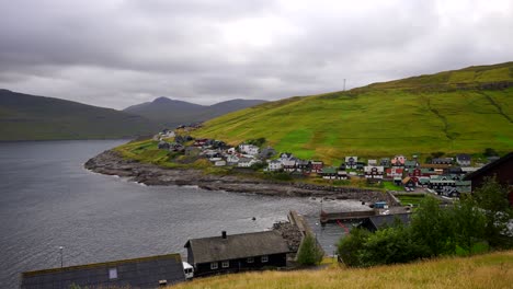 Static-wide-shot-showing-Kvivik-village-with-colorful-houses-and-tranquil-Atlantic-Ocean-during-cloudy-day