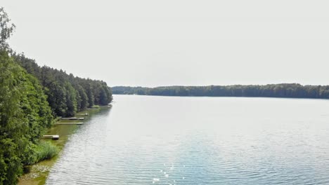 Aerial-Drone-shot-Over-a-Lake-and-Alongside-a-Forest-in-Borowy-Młyn,-Pomeranian-Voivodeship,-Poland