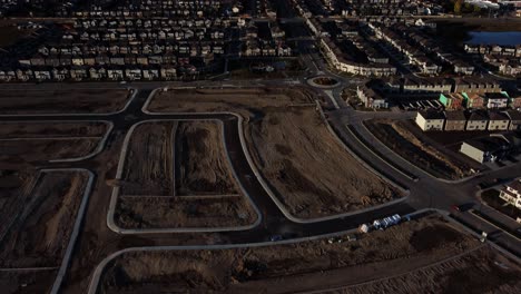 Flying-over-an-under-construction-community-during-the-golden-hour-in-Calgary,-Canada