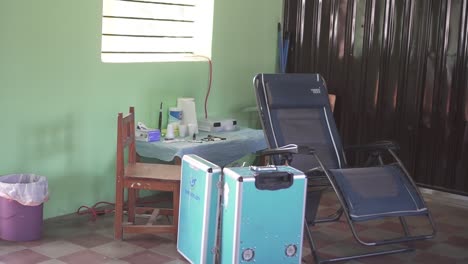 Chair-and-mobile-dental-equipment-installed-for-a-medical-brigade-in-a-poor-community,-in-an-improvised-clinic-in-a-school