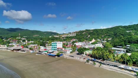 Hotel-resort-with-large-empty-beach-in-San-Juan-del-Sur,-Nicaragua,-aerial-orbit