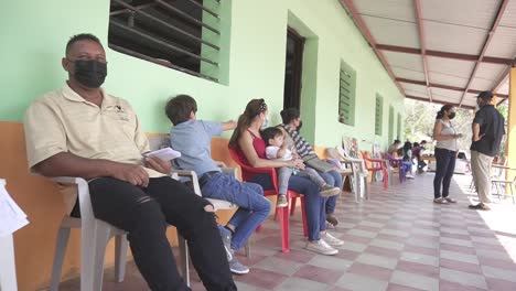 People-sitting-waiting-for-a-medical-consultation-during-a-health-brigade,-in-an-improvised-clinic,-in-a-poor-community-school