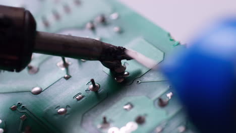 Der-Ingenieur-Ersetzte-Den-IC-Transistor-Durch-Einen-Lötkolben-Auf-Der-Leiterplatte-Der-Elektrischen-Schaltung,-Um-Das-Gerät-Zu-Reparieren