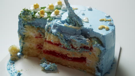 Slicing-a-fluffily-layered-cake,-filled-with-decadent-strawberry-filling,-topped-with-a-deliciously-soft,-sweet,-and-delectable-blue-buttercream-frosting