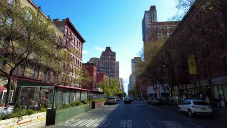 Pov-car-drive-on-road-in-New-York-City-during-sunny-day-between-american-Architecture