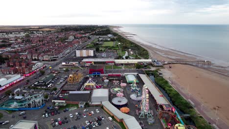 Aerial-footage-provides-a-glimpse-of-a-captivating-sunset-over-the-seaside-town-of-Skegness-in-the-UK,-featuring-the-town,-promenade,-pier,-and-the-coastline