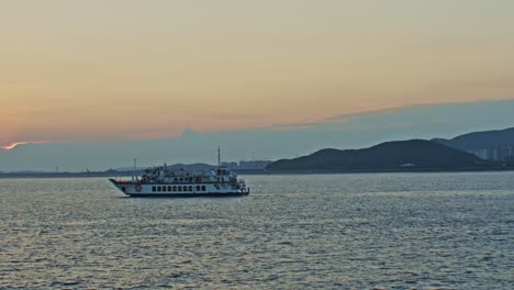 Nice,-beautiful,-picturesque,-calm-and-charming-sunset-in-front-of-the-sea-with-boat-ship-ferry-cruise,-horizon,-clouds,-sun,-seagulls,-birds-water-and-waves-wide-angle-landscape-panoramic-view