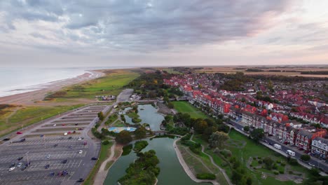 Aerial-video-captures-the-beauty-of-a-tranquil-sunset-in-Skegness,-a-charming-seaside-town-in-the-UK,-with-a-focus-on-the-town,-promenade,-pier,-and-coastline