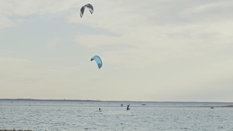 A-skilled-kitesurfer-jumps-in-the-air-in-slow-motion,-filmed-on-the-Nordic-coastline-of-Estonia