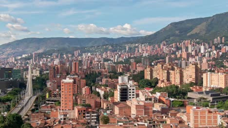Metropolis-city-Medellin-on-a-sunny-summer-day,-aerial-telephoto-establisher