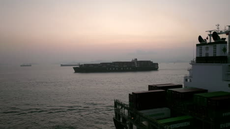 Drone-lifting-shot-of-Evergreen-container-vessel-passing-a-Yang-Ming-vessel-after-sunset