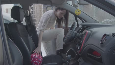 A-European-woman-slipping-the-lumber-support-pillow-in-driver's-seat-to-have-a-comfortable-sitting-position-to-avoid-lower-back-pain