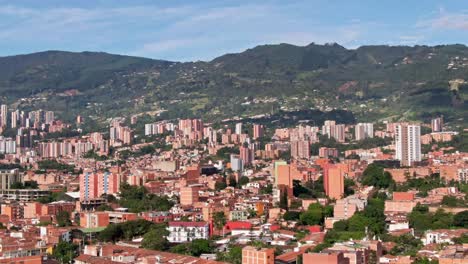 Telephoto-aerial-over-drug-cartel-city-Medellin,-Colombia,-skyline-and-mountain
