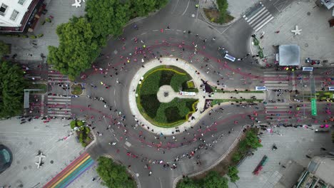 landing-drone-shot-of-runners-at-maraton-de-la-ciudad-de-mexico-passing-a-roundabout
