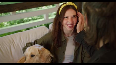 The-brunette-guy-strokes-the-brunette-girl-on-the-cheek.-A-girl-with-a-yellow-bandage-in-a-green-sweater,-a-dog-sits-near-the-girl