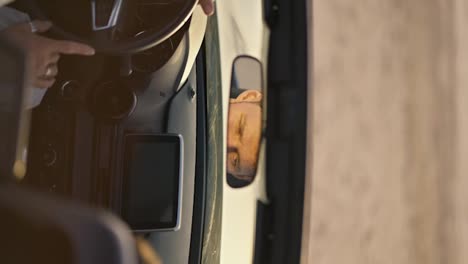 Vertikales-Video:-Ein-Mann-Blickt-Nachdenklich-In-Den-Autospiegel-Und-Legt-Seinen-Finger-Auf-Das-Lenkrad-Des-Autos