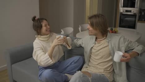 Close-Up-smiling-couple-drinking-tea-at-home-together,-happy-woman-talking-emotionally