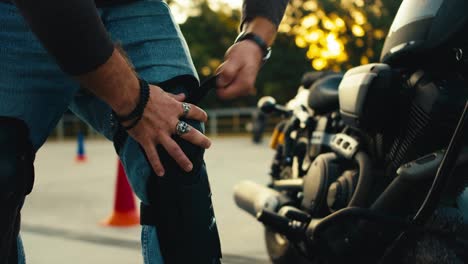 Close-up-shot-of-a-male-biker-putting-on-big-knee-pads.-Safe-riding-motorcycles-and-bikes