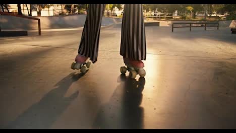 Zoom-out:-A-girl-with-a-short-haircut-in-a-purple-top,-striped-pants-and-red-headphones-roller-dances-in-a-skatepark-at-sunset-in-summer