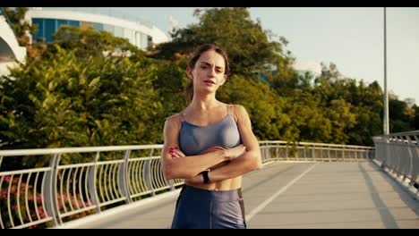 Portrait-of-a-girl-in-a-sports-summer-uniform-after-jogging-in-the-morning.-Athletic-girl-posing-and-looking-at-the-camera-with-her-arms-folded-across-her-chest