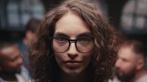 Shot-close-up-portrait-of-a-brunette-girl-with-curly-hair-in-glasses-who-falls-into-the-hands-of-other-participants-in-group-therapy.-Practice-mutual-support-in-group-therapy