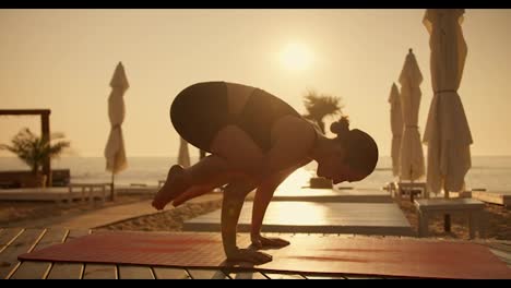 Ein-Brünettes-Mädchen-In-Einer-Sommersportuniform-Macht-Yoga-Und-Nimmt-Im-Sommer-An-Einem-Sonnigen-Strand-Auf-Einer-Roten-Matte-Eine-Vogelpose-Ein