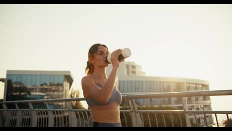 Ein-Glückliches-Mädchen-In-Einer-Sportlichen-Sommeruniform-Trinkt-Morgens-Wasser-Aus-Einer-Speziellen-Sportflasche