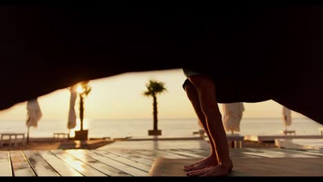 Two-guys-stretch-to-the-side-and-do-yoga-on-a-sunny-beach-in-the-morning.-Morning-exercises-and-zen