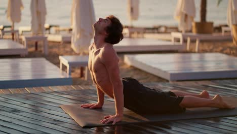 Ein-Mann-Mit-Nacktem-Oberkörper-Nahm-Morgens-Am-Sonnigen-Strand-Einen-Speziellen-Strip-Für-Yoga-Und-Meditation.-Morgens-An-Einem-Privatstrand-Trainieren