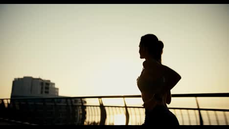 Rear-view-of-the-silhouette-of-a-sports-girl-who-is-jogging-in-the-morning.-Active-lifestyle