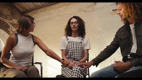 Zoom-in:-A-brunette-girl-with-curly-hair-with-glasses-in-a-checkered-jumpsuit-talks-about-her-problem,-the-rest-of-the-group-therapy-participants-support-the-girl