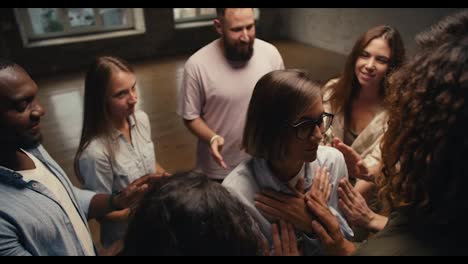 A-girl-with-a-bob-haircut-and-glasses-with-her-eyes-closed-leans-on-the-group-therapy-participants,-who-in-turn-passes-her-to-the-Circle.-Practicing-trust-in-group-therapy
