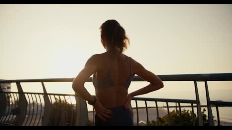 A-girl-in-sportswear-looks-at-the-sunset-on-a-morning-run-in-the-morning.-Morning-run-as-a-healthy-lifestyle