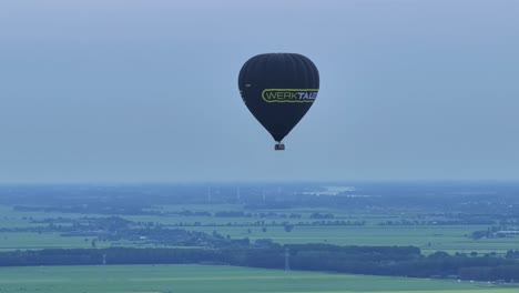 Hot-air-balloon-with-passengers-rising-on-a-cold-morning-over-misty-Holland
