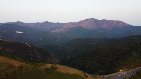 A-drone-tilts-over-a-highway-in-the-mountains-in-Pico-De-Los-Reales,-Estepona,-Spain