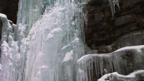 Ice-formations-from-frozen-waterfall,-Ausable-Chasm,-Adirondacks,-tilting-view