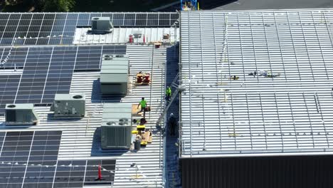 Solar-panel-installation-company-workers-on-metal-industrial-roof