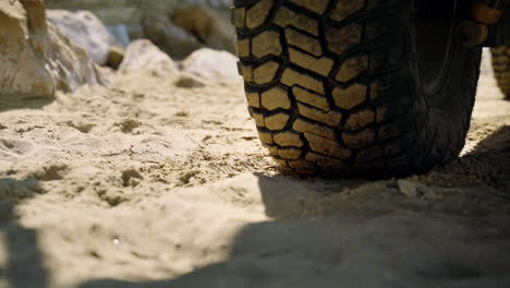 Close-up-of-a-tire-on-the-car,-parked-on-a-beach