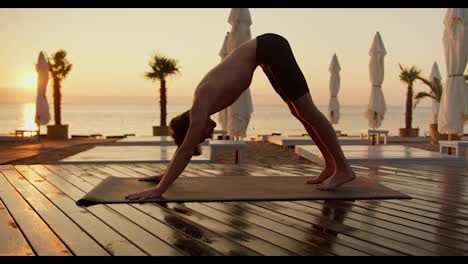 Rezension-Eines-Mannes,-Der-Morgens-Yoga-Macht.-Der-Typ-Steht-Morgens-Auf-Seiner-Hand-Am-Mit-Brettern-Bedeckten-Strand