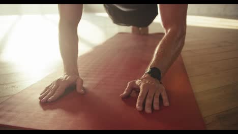 Close-up-shot-of-a-man's-hands-doing-push-ups-on-a-special-red-rug.-Tired-sweaty-hands-of-athletes-on-which-veins-are-visible