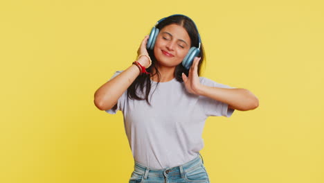 Feliz-Y-Divertida-Mujer-India-Con-Auriculares-Escuchando-Música-Bailando-Discoteca-Divirtiéndose-Relajándose-En-La-Fiesta
