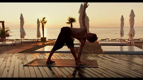 Yoga-classes-in-the-morning.-Young-guy-doing-yoga-at-sunrise-on-the-beach
